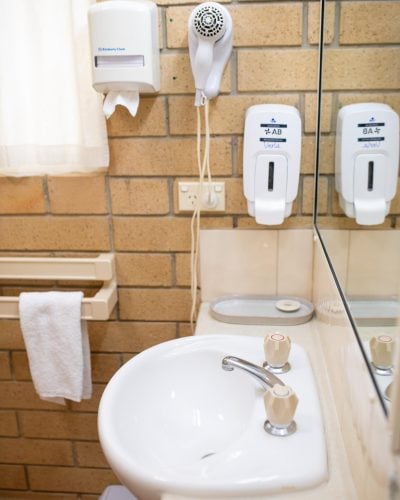 White bathroom essentials and white lavatory in the Queen Single Room at Mundubbera Motel