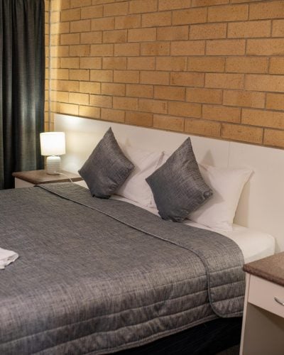 Grey and white bed and bedside tables with table lamps