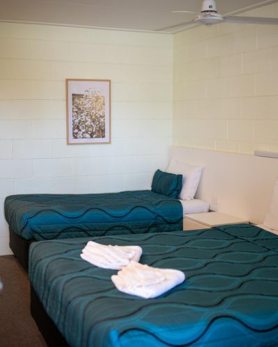 A queen and single bed inside a queen single room at Mundubbera Motel