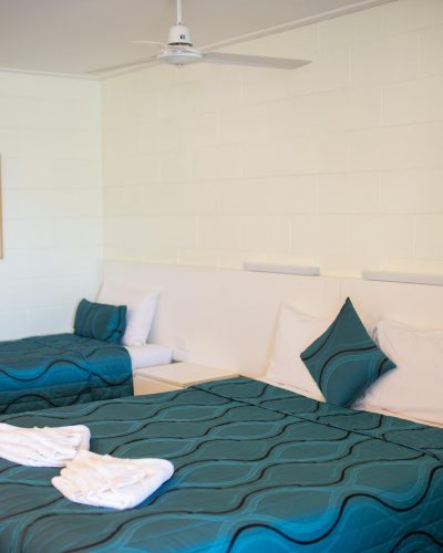 A queen and single bed inside a queen single room at Mundubbera Motel