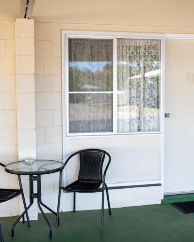 Black chairs and a round table outside Room 9 at Mundubbera Motel