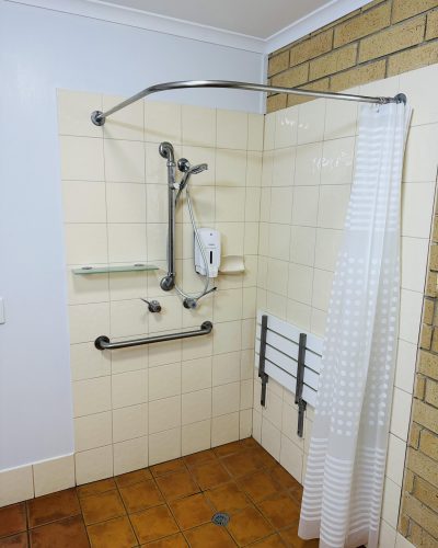 Clean bathroom with shower and heater of a Disabled Access Room